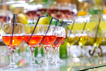Glasses of cocktails on party background