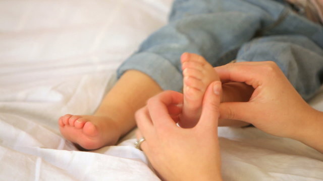 Mother tickling child's feet, closeup