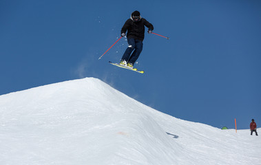 Fototapeta na wymiar Skifahrer springt über Hügel