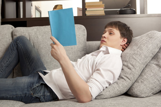 Smiling relaxed man reading a book