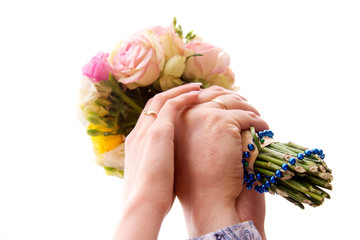 Hands with wedding rings on bridal bouquet. isolated