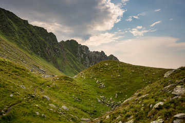 Fototapeta premium Romanian mountains, Carpathians, with green mountainsides and blue sky with clouds