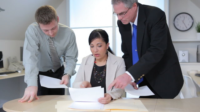 Group of businesspeople look at paperwork together