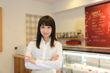 カフェで腕組みして立っている可愛いウエイトレス
