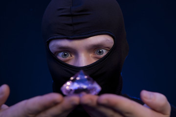 Thief. Man in black mask with a big emerald