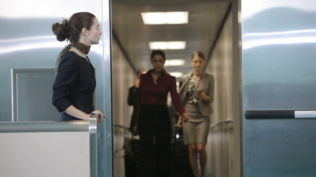 Airport passengers walk out of jet way door