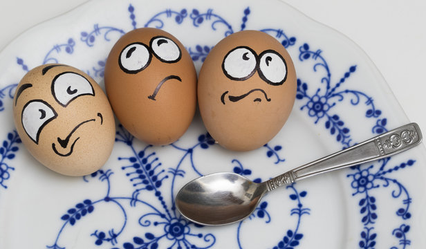Three frightened egg face on blue plate
