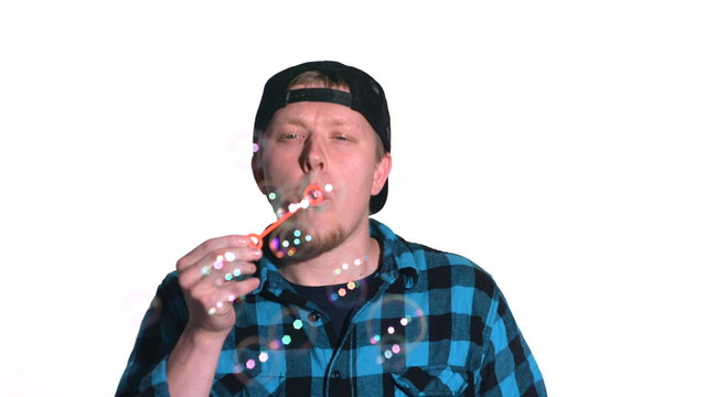 Man blowing bubbles and then hit in the face
