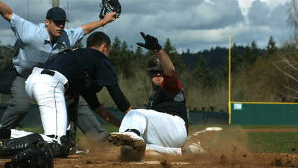 Baseball player slides is safe at home plate, slow motion - Powered by Adobe