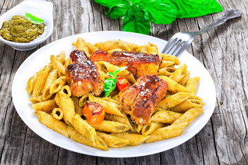 fried ribs with pasta penne and carrots, close-up