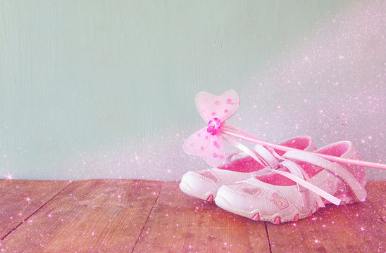 Small girls party outfit: Fairy Wand and white shoes on wooden table. bridesmaid or fairy costume. glitter overlay