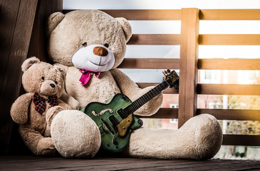 Family of fluffy teddy bears with a guitar.