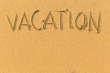 Vacation - word drawn on the sand beach.