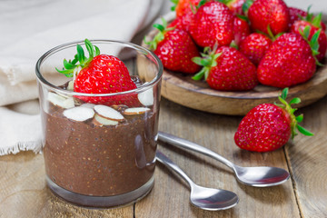 Chocolate chia seed pudding garnished with almond slices and strawberry