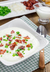 Creamy potato soup garnished with bacon and green onion