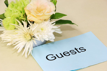 Guests card and flowers on dining table