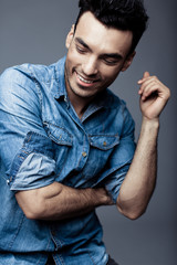 Portrait of handsome young man in casual denim clothes standing over white background