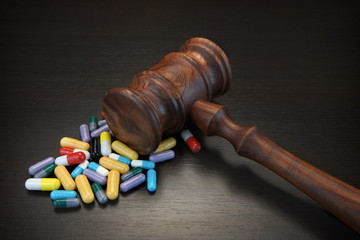 Judges Gavel And Medication On Black Wood Grunge Background