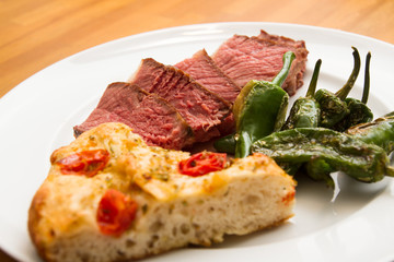 Steak with pimentos de padron and focaccia bread