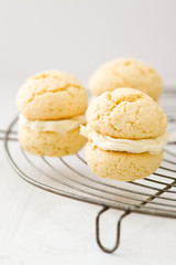 Three vanilla whoopie pies with buttercream filling on cooling rack