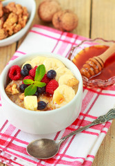 Healthy Breakfast. Oatmeal with fresh berries, bananas nuts and honey
