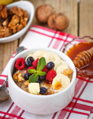 Healthy Breakfast. Oatmeal with fresh berries, bananas nuts and honey
