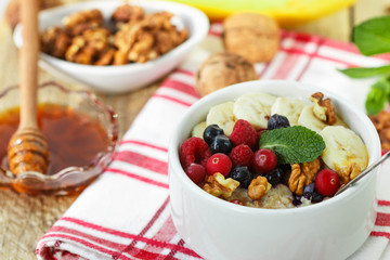 Healthy Breakfast. Oatmeal with fresh berries, bananas nuts and honey
