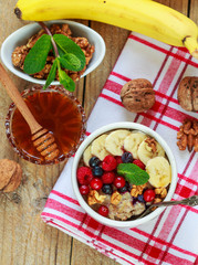 Healthy Breakfast. Oatmeal with fresh berries, bananas nuts and honey
