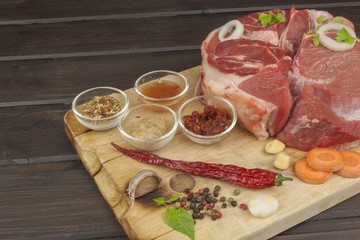 Spices and raw beef shank on the cutting board. Preparing spicy food. Decorations for the menu. Beef ready for cooking.
