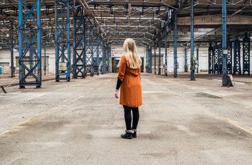 Frau allein in Fabrikhalle