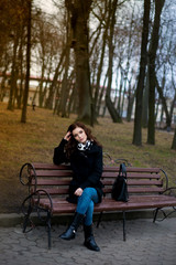 Beautiful girl sitting on a park bench