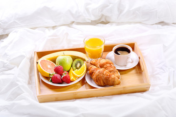 Breakfast in bed. Tray with coffee, croissants and fruits