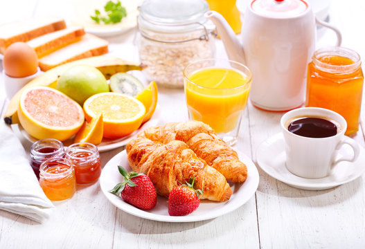 Breakfast with croissants, coffee, orange juice, toasts and frui