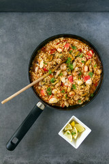 Spanish dish called paella with seafood, on the pan, grey background.