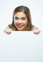 Woman looks out from behind white blank sign board.