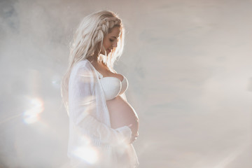 Fototapeta na wymiar Portrait of a beautiful pregnant woman in white lingerie and long hair, lifestyle, waiting, belly