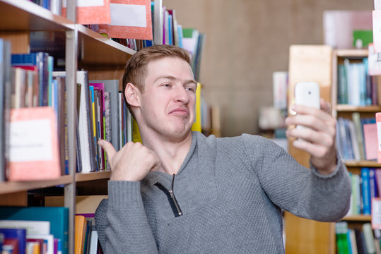 Male student taking selfie in college library