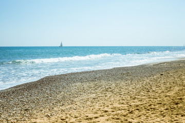 Fototapeta na wymiar playa de piedra y velero