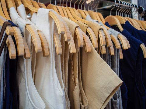  fashion clothes of different colors on wooden hangers