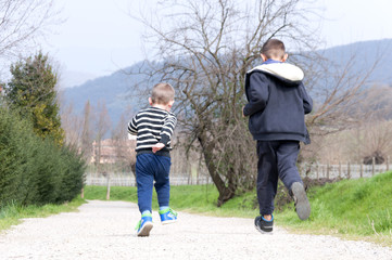 Fototapeta premium two boys run on rural road