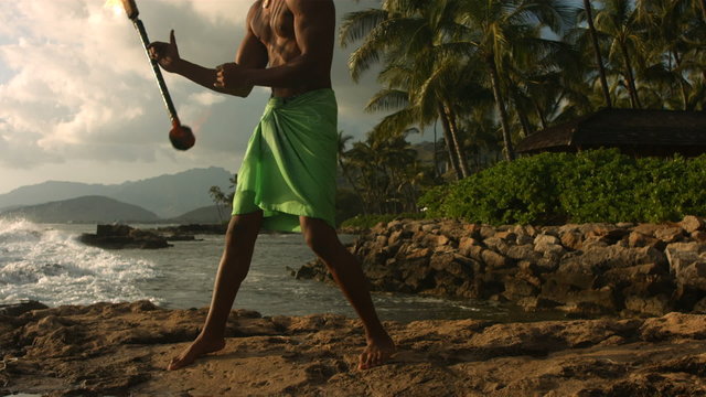 Hawaiian fire knife dancer performs, slow motion.