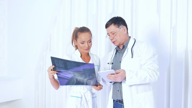Medical doctors team with MRI spinal scan portrait against white modern background.