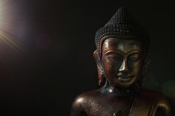 Wooden bronze buddha on black background