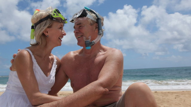 Senior couple at beach with snorkel gear