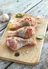 Raw chicken legs with paprika, seasoning and garlic