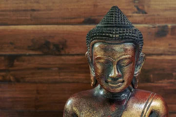 Peel and stick wallpaper Buddha Wooden bronze buddha on wooden blurred background
