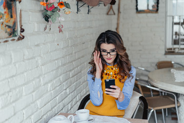 lady sitting at the table in cafe using phone