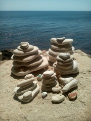 Fototapeta na wymiar Баланс из белых камней на морском берегу летом