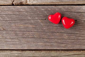 Two candy hearts over wood
