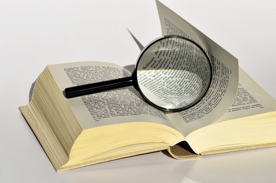 Offenes Buch mit Leselupe